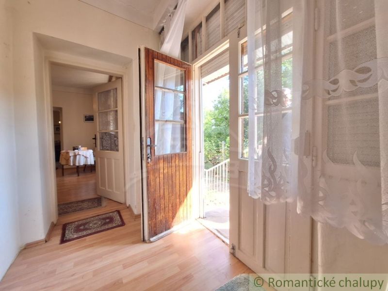 A hallway in a family house with a view of the garden and a wooden decor floor.