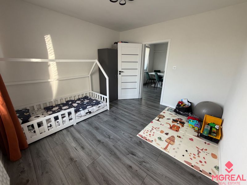 Children's room in a 3-room apartment with a gray-brown floor with a wood decor.