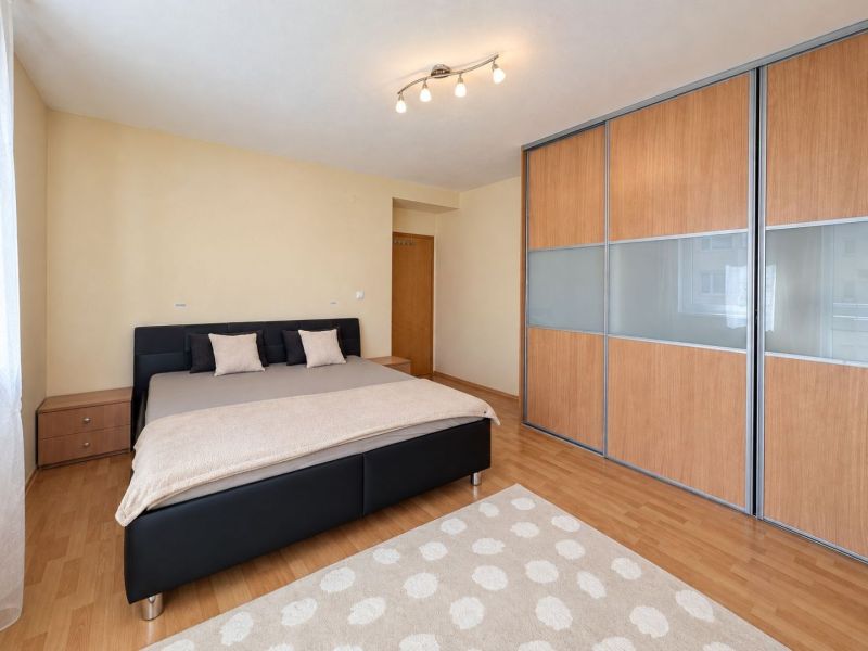 A children's room with pink curtains and a wooden decor floor in a 3-room apartment.
