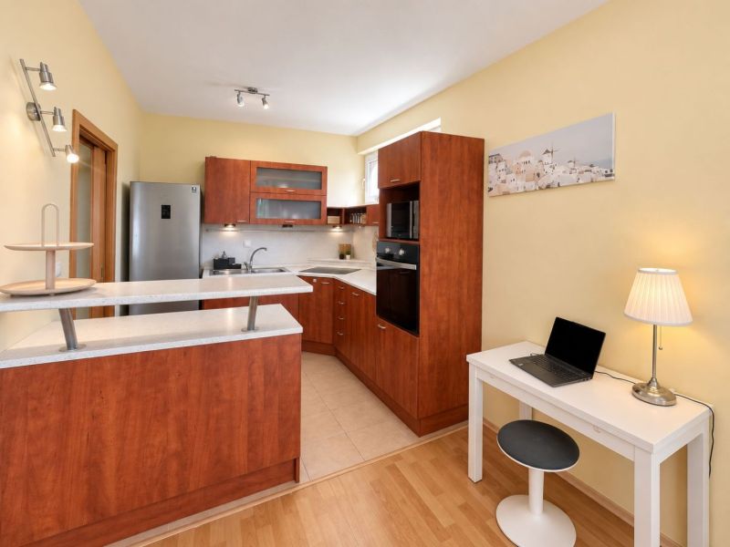 A kitchen with wooden decor in a 3-room apartment, light wall, white countertop.