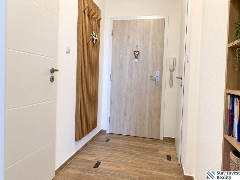 Entrance hallway in a 3-room apartment with a wooden decor floor.