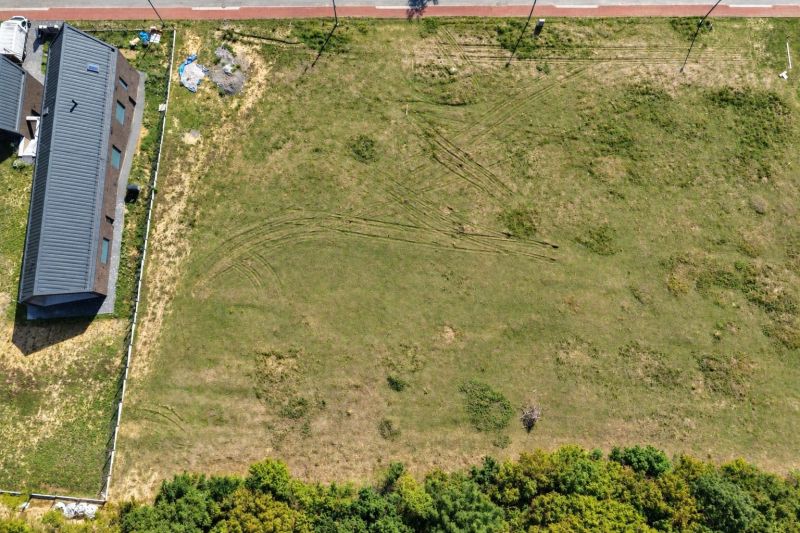 A top-down view of development plots near Borinka with a nearby building and greenery.