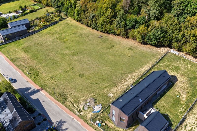 Aerial view of development plots in Borinka surrounded by greenery and a road.