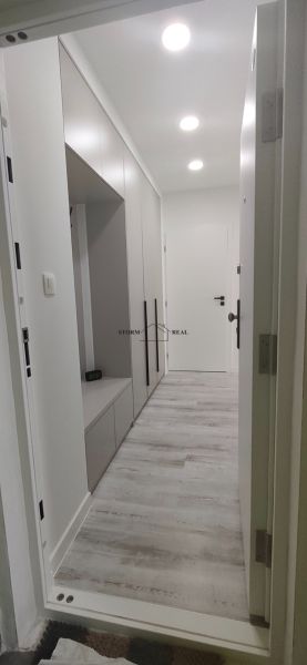 A hallway in a 3-room apartment with white door frames and a built-in wardrobe.