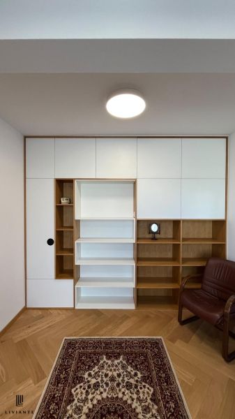 Living wall with shelves and a seat, floor with wood decor, carpet.