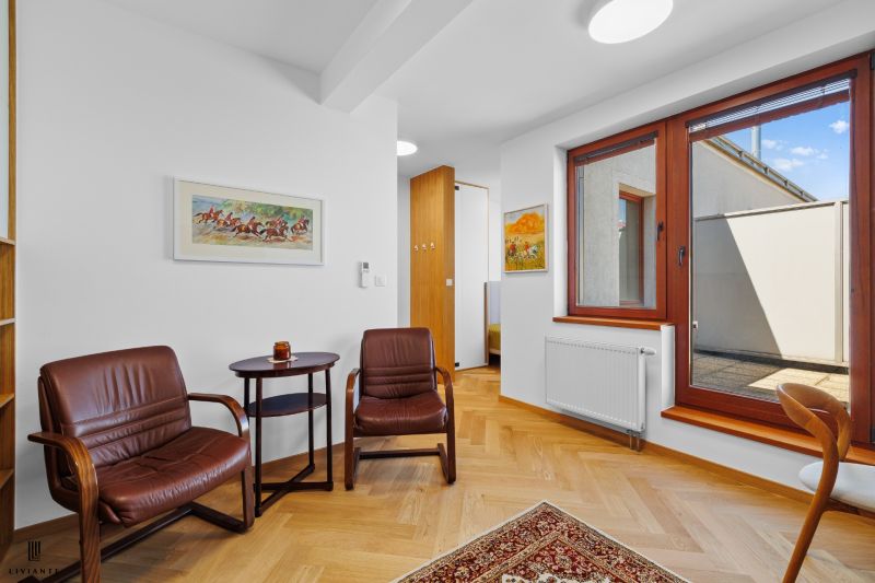 Interior of a 3-room apartment with a wooden decor floor and leather armchairs.