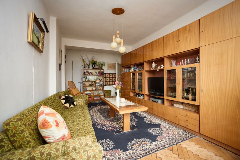 Living room in a 3-room apartment with a carpet and a wooden decor floor.