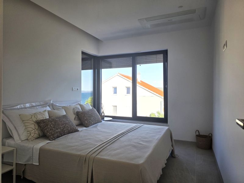 Bedroom with a large bed and a view of the sea, floor with wooden decor.