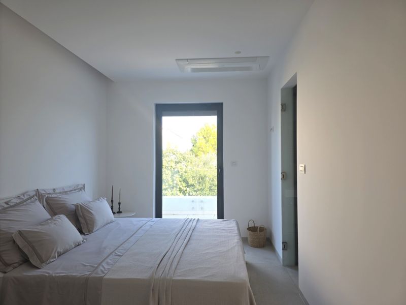 Bright bedroom in a 4-room apartment with a view, the bed is made.