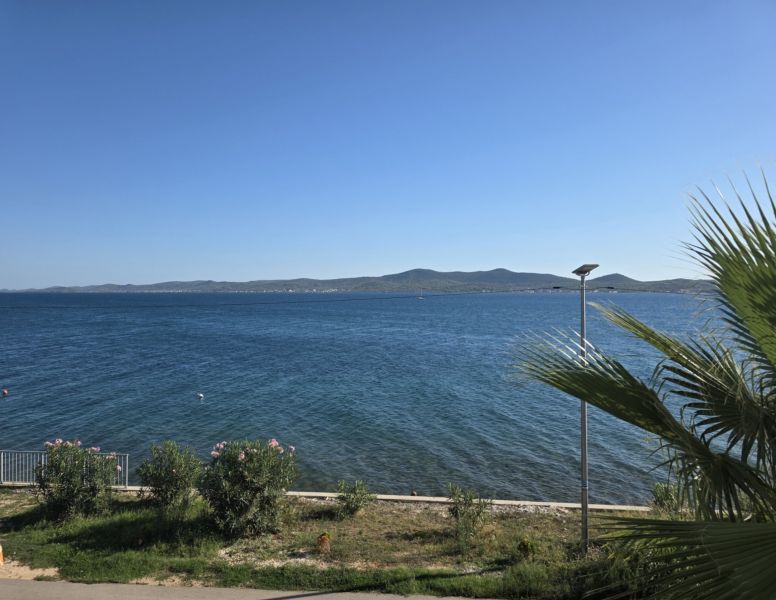 The coast in Sukošan with a view of the sea and surrounding mountains.