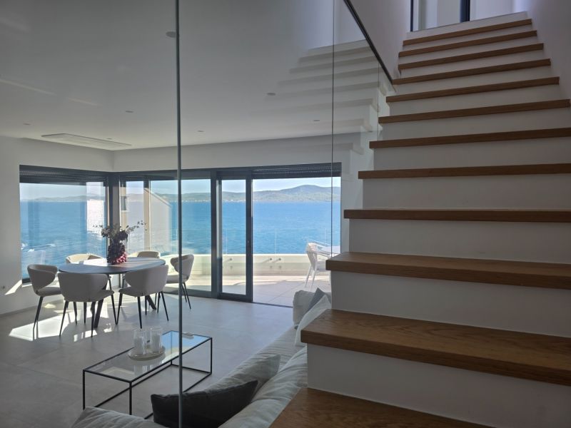 Interior of a 4-room apartment with a sea view, stairs with wooden decor.