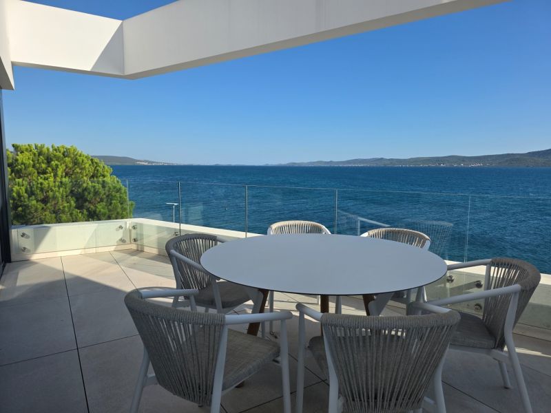 Terrace of a 4-room apartment in Sukošan with a view of the sea and the surrounding landscape.