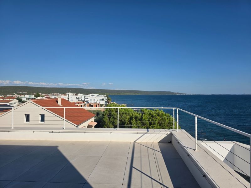 View of the rooftop terrace of an apartment building in Sukošan with the sea and coastal landscape.