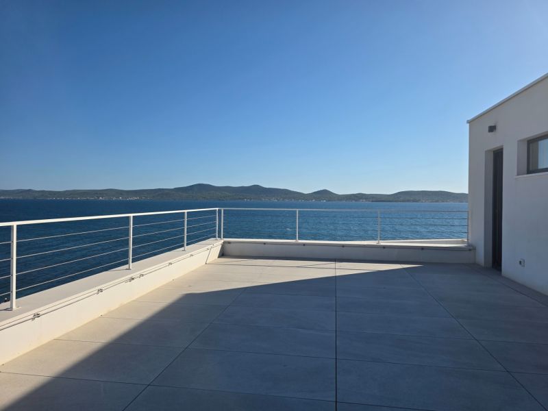 A terrace with a view of the sea and surrounding countryside in Sukošan at a 4-room apartment.