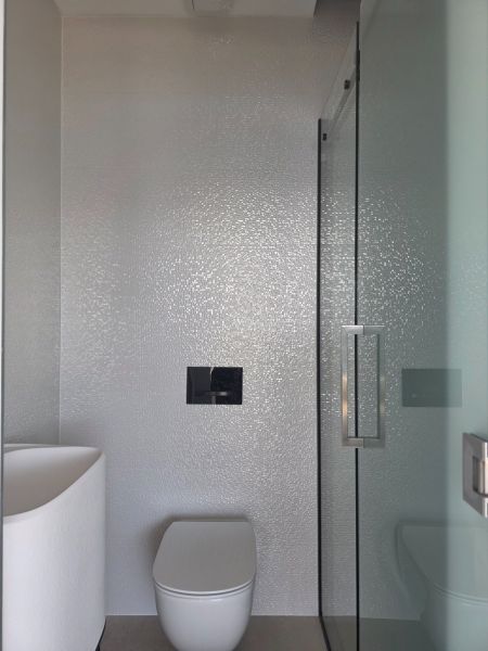 Bathroom with a shower and toilet in a 4-room apartment, simple and clean design.