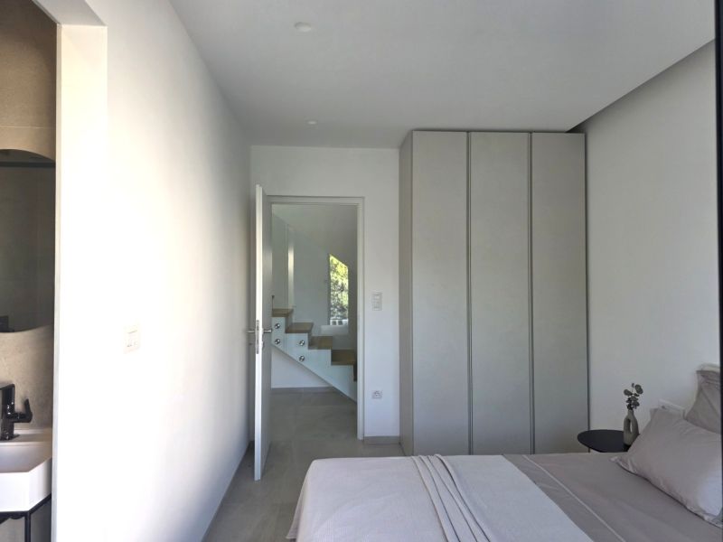 Bedroom in a 4-room apartment with entrance to the bathroom and white staircase.
