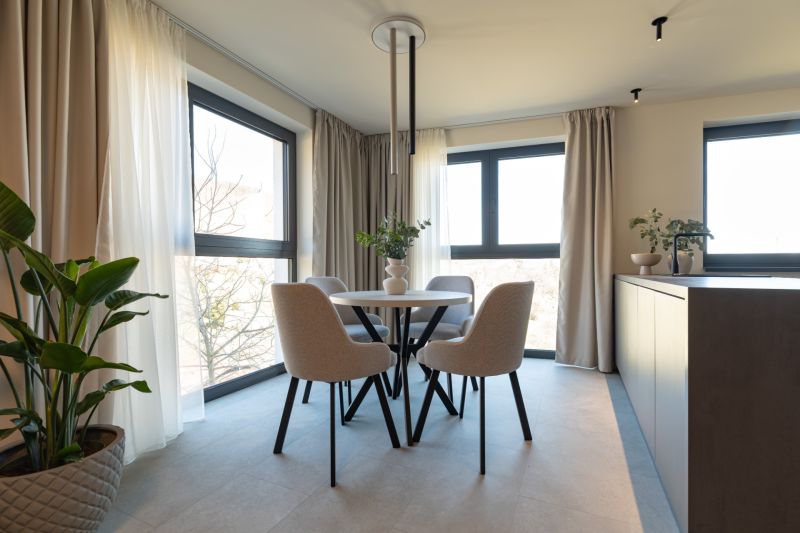 Dining room with a table and four chairs, famous flowers, and curtains in a 4-room apartment.