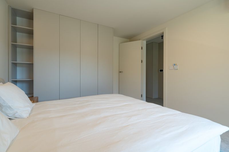 Bedroom with wardrobes, bed, and open doors in a 4-room apartment.