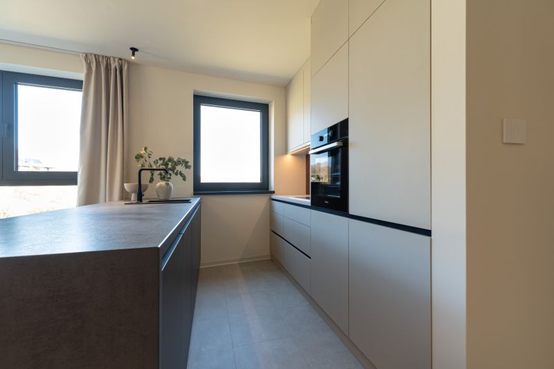 A kitchen in a 4-room apartment with modern appliances and light furniture.