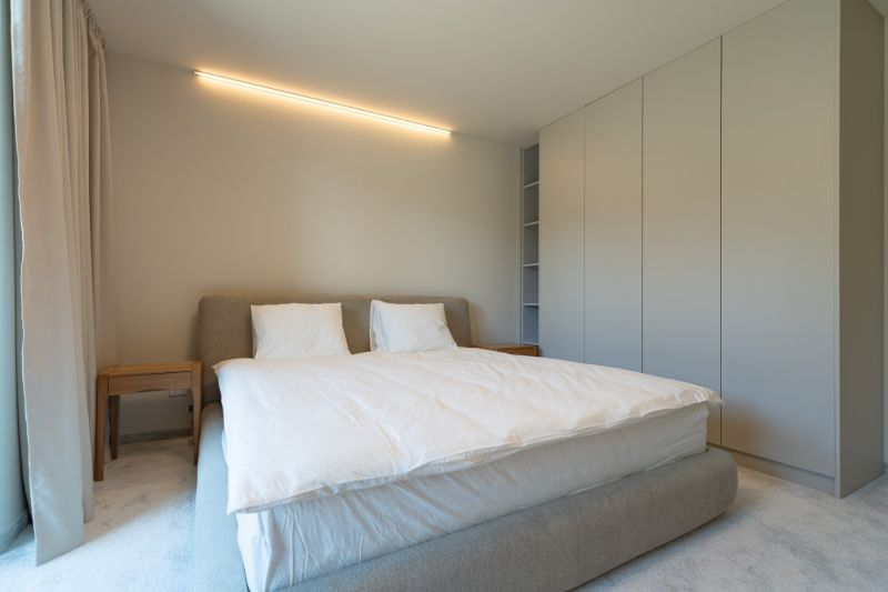 Bedroom in a 4-room apartment with a large bed, wardrobe, and side table.