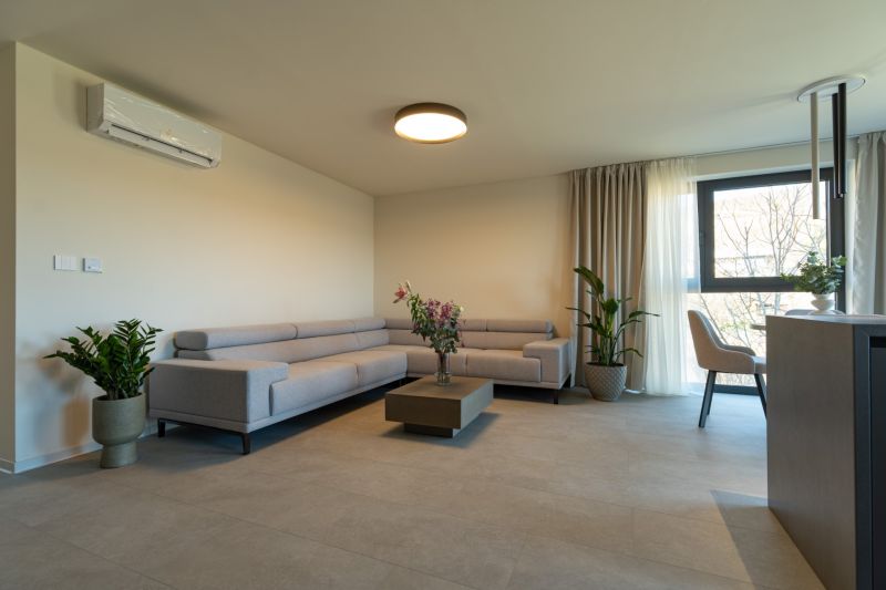 Living room in a 4-room apartment with a light sofa and plants.