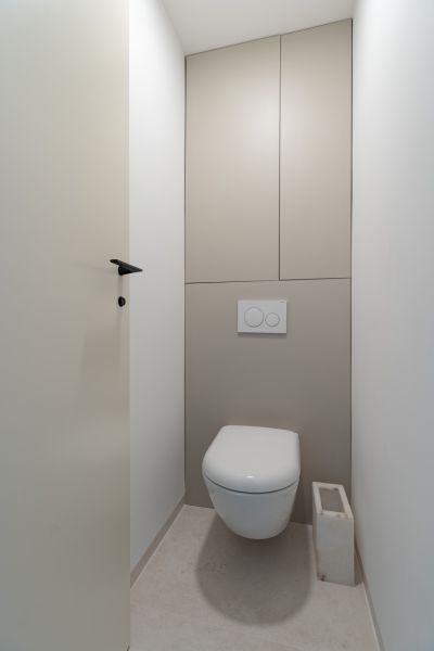 A toilet with a concealed flushing system in a 4-room apartment.