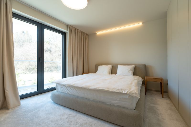 Bedroom with light walls, a bed, and a wardrobe in a 4-room apartment.
