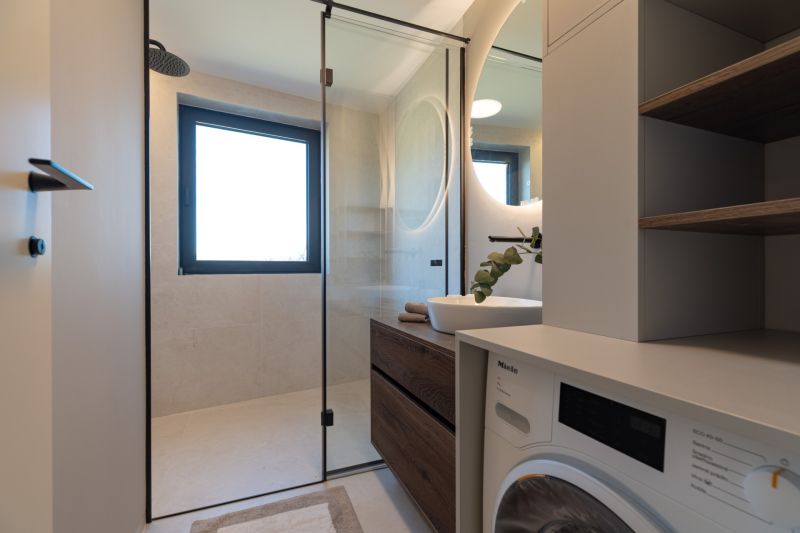 The bathroom in the 4-room apartment contains a shower, a sink, and a washing machine.