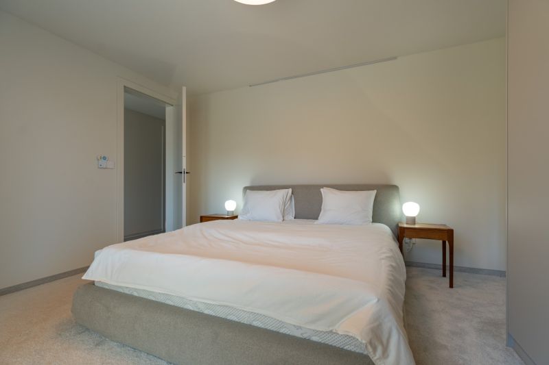 A bedroom in a 4-room apartment with a comfortable bed and nightstands.