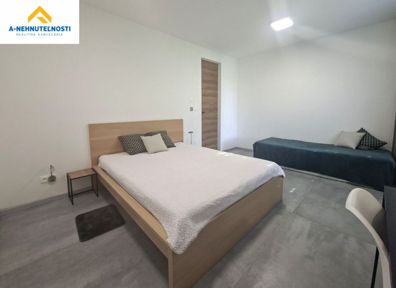 A bedroom in a two-room apartment with a bed, a second bed, and a table.