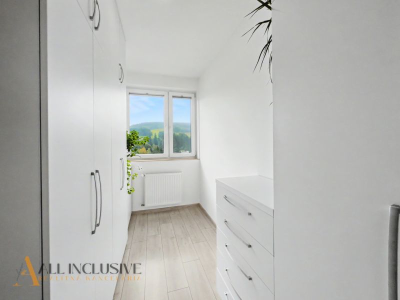 A bright room with white furniture and a wooden decor floor in a 2-room apartment.