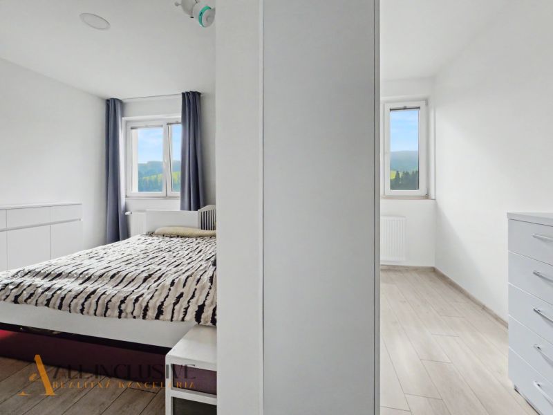 Bedroom and a bright room in a 2-room apartment with a wooden decor floor.