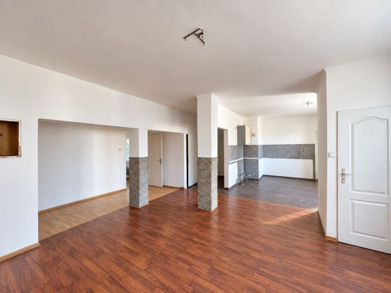 Open space with wood-decor flooring and a kitchenette for plots - living.