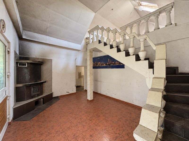 Interior with a tiled fireplace, staircase, and flooring, suitable for residential plots.