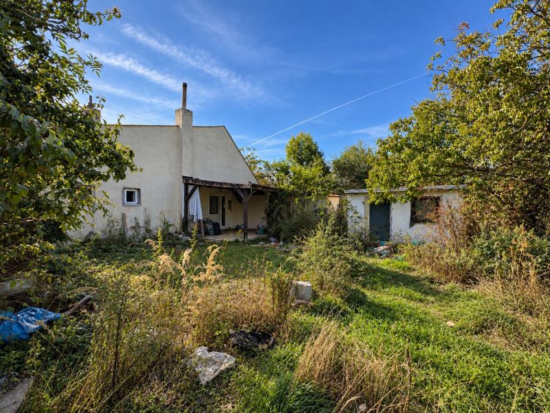 A family house surrounded by an overgrown garden on Hlavná Street in Dunajská Lužná, residential plots.