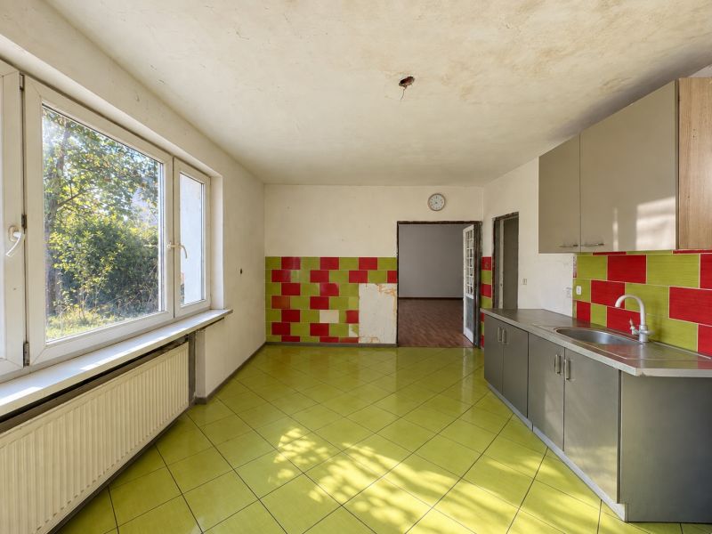 A kitchen with colorful tiles, green flooring, and a wooden decor floor, Properties - living.