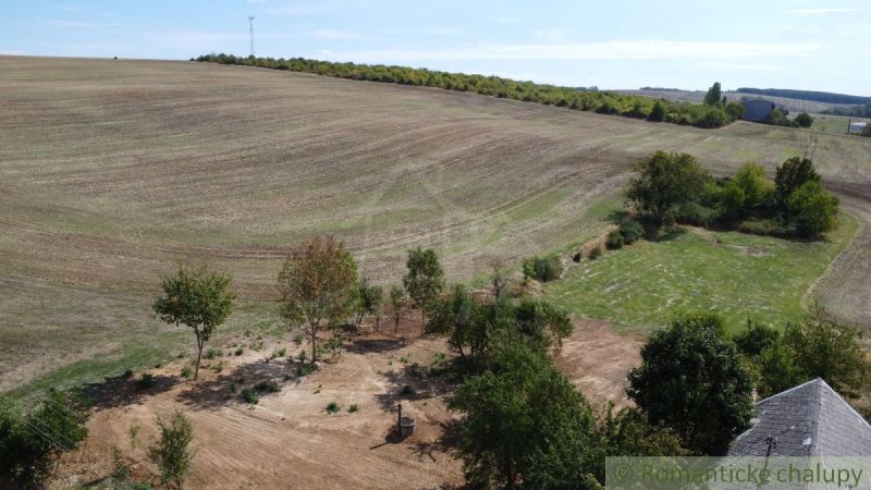 Spacious residential plots in the village of Dedinka with hilly terrain and trees.