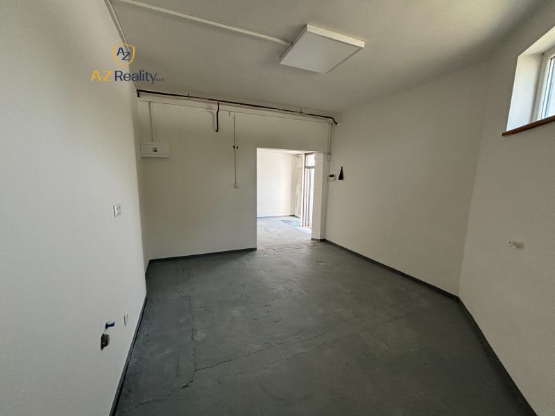 Interior space for rent with outlets and gray flooring in warehouses and halls.