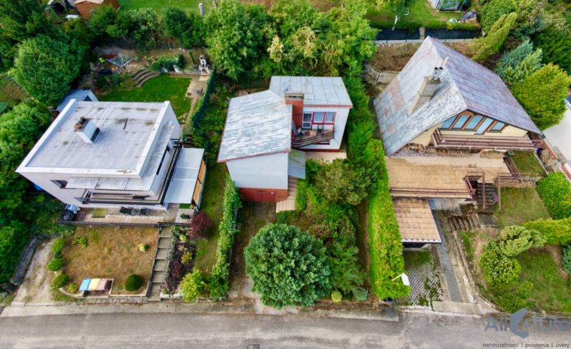 A cottage on Rekreačná Street in Vrbové surrounded by greenery and other buildings.