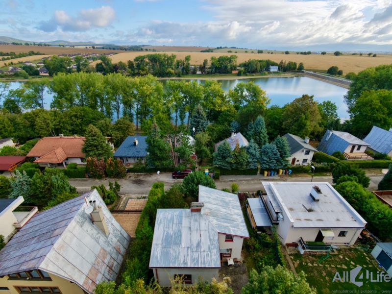 Cottage on Rekreačná Street in Vrbové by the lake, surrounded by greenery and houses.