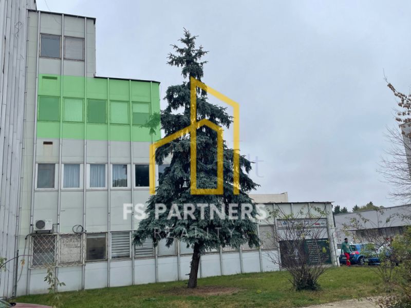 Office building on Záhradnícka Street in Komárno with a large tree in the foreground.