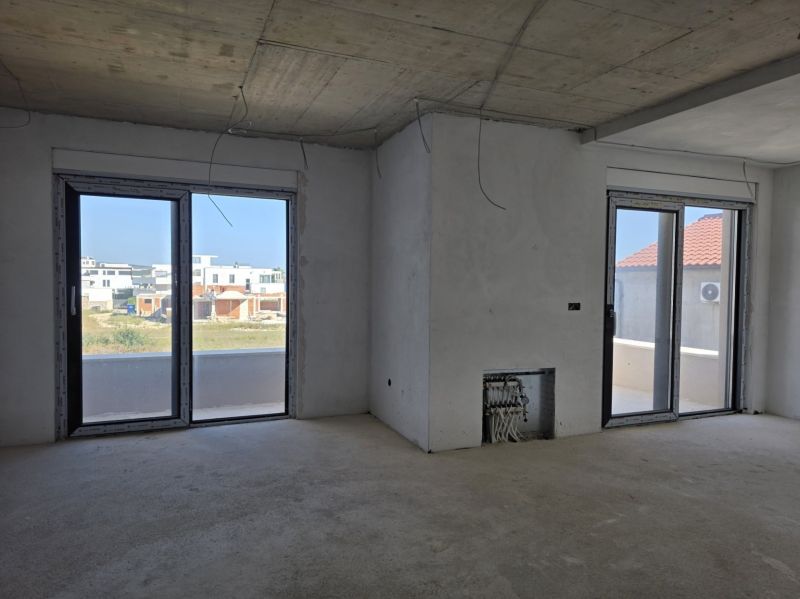 Interior of a 3-room apartment with large windows and a view of the outdoor construction.