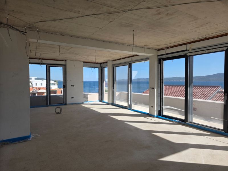 The view from a 3-room apartment in Sukošan of the sea through large windows.