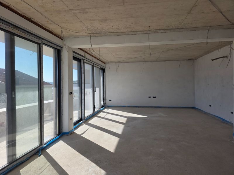 An unfurnished room with large windows in a 3-room apartment, floor with wood decor.