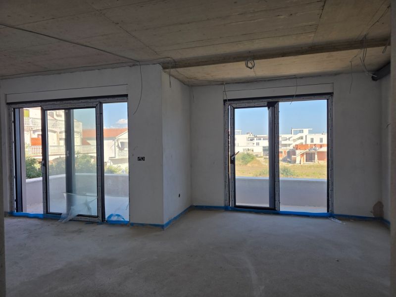 Interior of a 3-room apartment with large windows and a balcony offering a view.