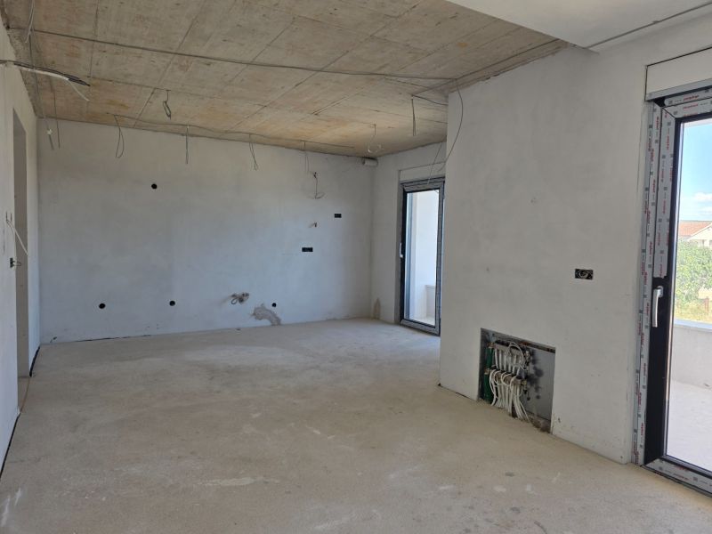 Interior of a 3-room apartment with a concrete ceiling and preparation for electrical installation.