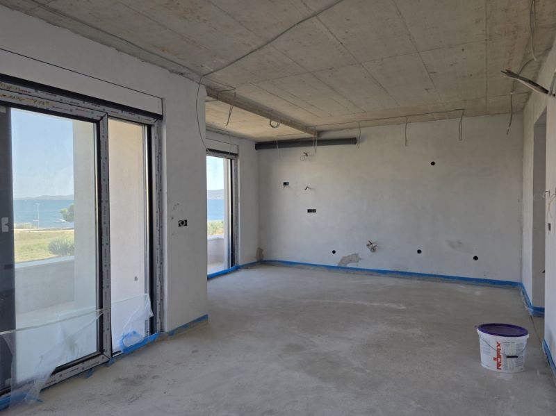 An empty interior of a 3-room apartment with a sea view, wooden decor flooring.
