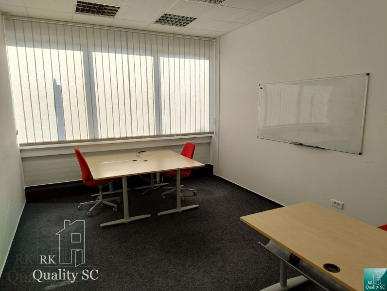 Offices with carpeted floors, desks, red chairs, and a whiteboard.