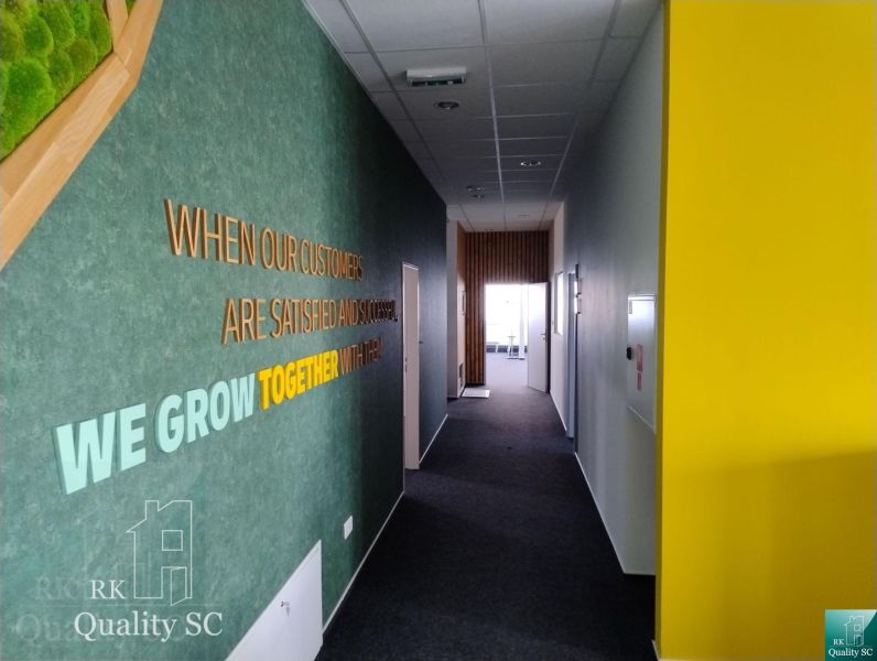 A hallway in offices with colorful walls and a motivational quote.