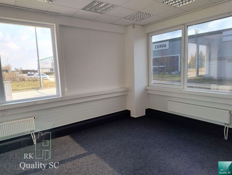 Offices with carpet and large windows, view of the exterior.